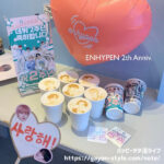 ENHYPENデビュー2周年記念イベント 福岡カフェ テーブルの上にラテプリントが施されたカフェラテが7つと、ハートのバルーンやミニスタンドバナーなどでディスプレイされた様子